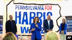 Democratic presidential nominee Vice President Kamala Harris speaks as second gentleman Doug Emhoff, from left, Democratic vice presidential nominee Minnesota Gov. Tim Walz and his wife Gwen Walz listen at a campaign event, Aug. 18, 2024, in Rochester, Pennsylvania. 