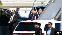 Former President Donald Trump (C) boards his plane at Palm Beach International Airport in West Palm Beach, Florida, April 3, 2023.