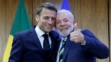 O Presidente do Brasil, Luiz Inácio Lula da Silva (à direita), e o Presidente da França, Emmanuel Macron (à esquerda), posam para uma fotografia durante uma cerimónia de assinatura de um acordo bilateral em Brasília, a 28 de março de 2024. 