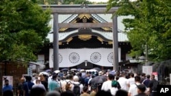 FILE - People queue to pay respects to the war dead at Yasukuni Shrine, Aug. 15, 2022, in Tokyo. 