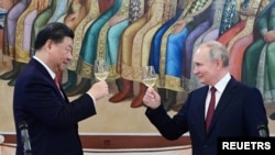 Presiden Rusia Vladimir Putin dan Presiden China Xi Jinping bersulang dalam pertemuan di Kremlin, Moskow, pada 21 Maret 2023. (Foto: Sputnik/Pavel Byrkin/Kremlin via Reuters)
