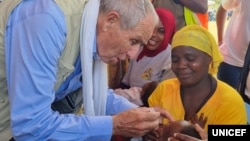 UNICEF representative Gianfranco Rotigliano gives oral vaccine to a child during the launch of the nationwide typhoid vaccination campaign, May 11, 2023, in Malawi's Balaka district. (UNICEF Malawi)