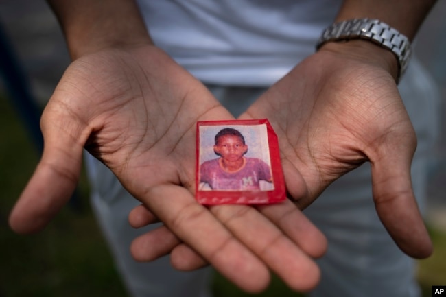 Mohamed, who fled political persecution in Mauritania, holds a picture of himself as a child, May 22, 2023, outside the Crossroads Hotel in Newburgh, N.Y.
