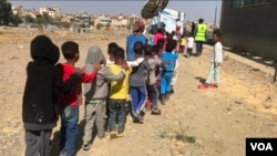 Children walk in a line at the Mai Weyni school in the Tigray regional capital, Mekelle. (Mulugeta Atsbaha/VOA)