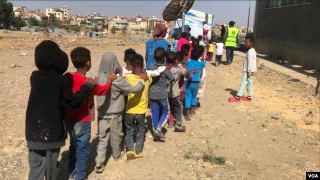 Children walk in a line at the Mai Weyni school in the Tigray regional capital, Mekelle. (Mulugeta Atsbaha/VOA)