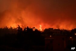 Fire burns the forest near houses in La Orotava in Tenerife, Canary Islands, Spain, Aug. 19, 2023.