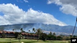 Smoke rises in the hills above the Kaanapali resort hotel area of Lahaina, Hawaii, August 26, 2023. A brush fire Saturday caused Maui to evacuate residents from a neighborhood of Lahaina.