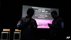 Staff stand in front of the screen prior to a planned livestream of the lunar landing event, at Miraikan, the National Museum of Emerging Science and Innovation, in Tokyo, April 26, 2023.