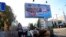 People walk out from an underground crossing decorated with a United Russia party poster that reads: "For Donbas where you want to live!" prior to local elections in Donetsk, the capital of Russian-controlled Donetsk region, eastern Ukraine, Sept. 7, 2023