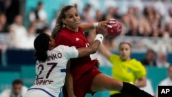 Katrin Klujber of Hungary tries to shoot the ball against Minko Estelle Nze of France, during the women's handball match between France and Hungary at the 2024 Summer Olympics in Paris, July 25, 2024.