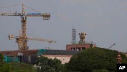 ভারতের নয়া দিল্লিতে নির্মাণাধীন সংসদ ভবনের ছাদে দেশটির জাতীয় প্রতীক দেখা যাচ্ছে। রবিবার, ১১ সেপ্টেম্বর, ২০২২। (এপি ছবি/মণীশ স্বরূপ)