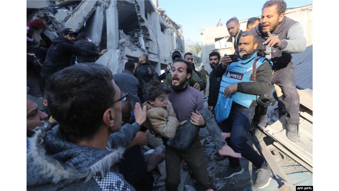 Seorang pria Palestina mengevakuasi seorang gadis yang terluka dari lokasi serangan Israel di daerah Zawayda di Jalur Gaza tengah pada 30 Desember 2023. (Foto: AFP)
