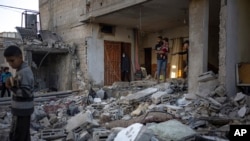 Palestinians look at the destruction after an Israeli strike in Rafah, southern Gaza Strip, Dec. 29, 2023. 