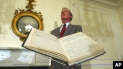 FILE - Archivist of the U.S John Carlin stands behind a 1947 Harry Truman presidential diary, July 10, 2003, at the National Archives in Washington. Presidents from George Washington to Joe Biden have kept presidential diaries. (AP Photo/Rick Bowmer, File)