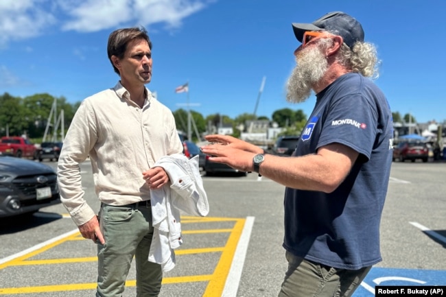 Tom Hedstrom, chair of the Select Board, speaks with schooner captain Aaron Lincoln during a visit to the harbor, Tuesday, June 4, 2024, in Camden, Maine. (AP Photo/Robert F. Bukaty)