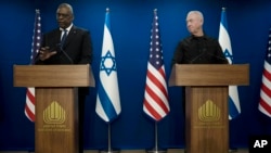 Israel Minister of Defense Yoav Gallant, right, listens to his U.S. counterpart, Secretary of Defense Lloyd Austin, making a joint statement after their meeting about Israel's military operation in Gaza, in Tel Aviv, Dec. 18, 2023.