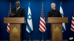 Israel Minister of Defense Yoav Gallant, right, listens to his U.S. counterpart, Secretary of Defense Lloyd Austin, making a joint statement after their meeting about Israel's military operation in Gaza, in Tel Aviv, Dec. 18, 2023. 