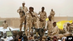 FILE - Sudanese soldiers from the Rapid Support Forces stand on their vehicle during a military-backed rally in Mayo district, Sudan, on June 29, 2019. Experts attribute some of the blame for the current political and social instability in Sudan on climate change.