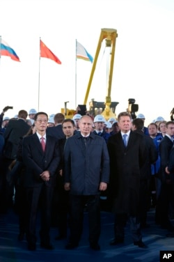 资料照：左起：时任中国副总理张高丽、俄罗斯总统普京和俄罗斯天然气工业股份公司首席执行官阿列克谢·米勒出席在雅库茨克地区举行的连接中俄的天然气管道“西伯利亚力量”开工仪式。（2014年9月1日）