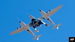 FILE - In this Feb. 13, 2020, file photo, Virgin Galactic's VSS Unity departs Mojave Air & Space Port in Mojave, Calif., for its SpaceFlight operations to New Mexico.