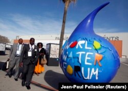 Peserta berjalan melewati logo Forum Air Dunia ke-6 di Marseille, 12 Maret 2012. (Foto: REUTERS/Jean-Paul Pelissier)