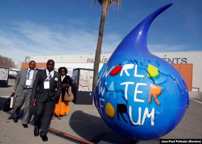 Peserta berjalan melewati logo Forum Air Dunia ke-6 di Marseille, 12 Maret 2012. (Foto: REUTERS/Jean-Paul Pelissier)