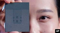 FILE - A Kunpeng 920 chip is displayed during a ceremony in Shenzhen, China, Jan. 7, 2019. China says foreign access to an academic database with information in such fields as politics, the humanities and technology will be limited starting April 1, 2023.