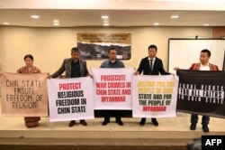 A group of Myanmar nationals hold banners during a press conference after filing a criminal complaint in Manila, Philippines, Oct. 25, 2023.