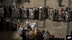 Muslim pilgrims line up in two rows, one for men and one for women, outside the Grand Mosque, during the annual hajj pilgrimage, in Mecca, Saudi Arabia, June 23, 2023.