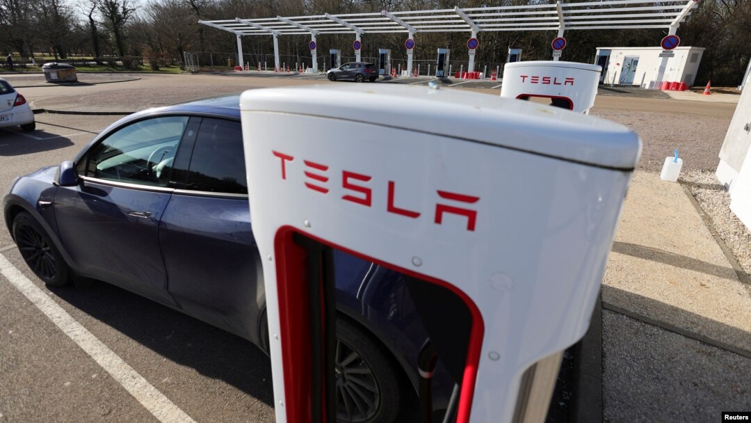 Un conductor recarga la batería de su auto Tesla en una estación Supercharge en Chateauvillain, Francia, el 20 de febrero de 2023.