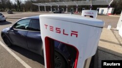 Un conductor recarga la batería de su auto Tesla en una estación Supercharge en Chateauvillain, Francia, el 20 de febrero de 2023.