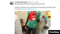 A Twitter screenshot of a medical worker standing as a back drop stand resuscitating a patient on the floor. 