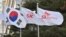 韩国芯片制造商SK海力士公司建筑外，韩国国旗与该公司的旗帜在飘扬。 （2024年1月25日）