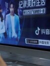 FILE - A pedestrian wearing a face mask following the coronavirus disease (COVID-19) outbreak walks past an advertisement of TikTok (Douyin) at a bus stop in Beijing, China Aug. 24, 2020.