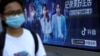 FILE - A pedestrian wearing a face mask following the coronavirus disease (COVID-19) outbreak walks past an advertisement of TikTok (Douyin) at a bus stop in Beijing, China Aug. 24, 2020.