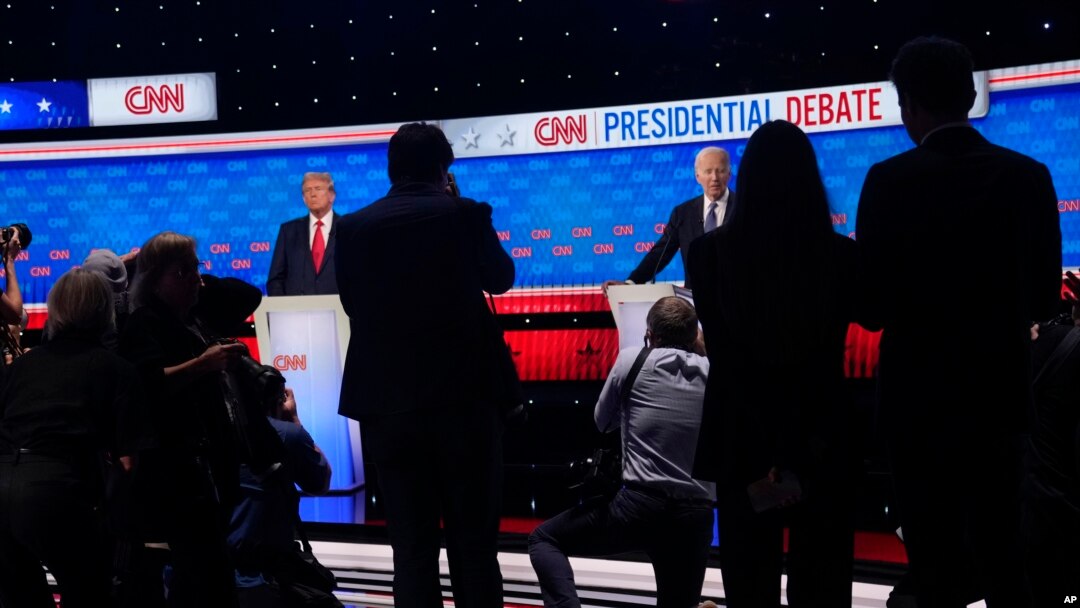 Photographers take photos of President Joe Biden, right, and Republican presidential candidate former President Donald Trump, left, during a break in a presidential debate hosted by CNN, June 27, 2024, in Atlanta. 