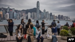 中国大陆游客在香港尖沙咀眺望维多利亚海湾对面的香港岛。（2024年1月17日）