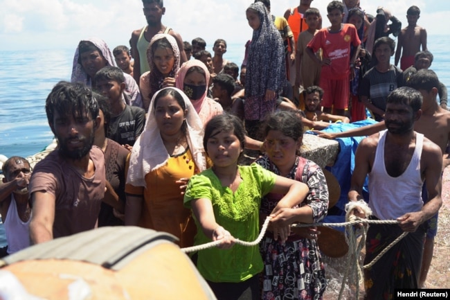 Pengungsi Rohingya memegang tali saat diselamatkan dari perahu yang terbalik di perairan Aceh Barat, 21 Maret 2024. (Foto: REUTERS/Hendri)