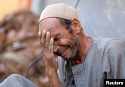 Hassan El Salheen weeps after burying the repatriated body of his son, Aly, who died along with his three cousins in Libya after Storm Daniel hit the country, at Al Sharief village in Bani Swief province, Egypt, Sept. 13, 2023.