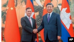 នាយករដ្ឋមន្ត្រីកម្ពុជា លោក ហ៊ុន ម៉ាណែត ចាប់ដៃជាមួយប្រធានាធិបតីចិនលោក Xi Jinping ក្នុងអំឡុងជំនួបមួយ នៅទីក្រុងប៉េកាំង ប្រទេសចិន កាលពីថ្ងៃទី ១៥ ខែកញ្ញា ឆ្នាំ ២០២៣។ (Cambodia's Prime Minister Telegram via AP)