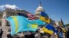 Pengunjuk rasa membawa bendera Kazakstan, AS, dan Ukraina di luar Gedung Kongres AS setelah voting undang-undang yang memberikan bantuan senilai $95 miliar kepada Ukraina, Israel, dan Taiwan. (Foto: REUTERS/Ken Cedeno)