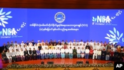 Senior Gen. Min Aung Hlaing, head of the military council, and other attendees sit for a group photo after a ceremony to mark the anniversary of the Nationwide Ceasefire Agreement at the Myanmar International Convention Center in Naypyitaw, Oct. 15, 2023.