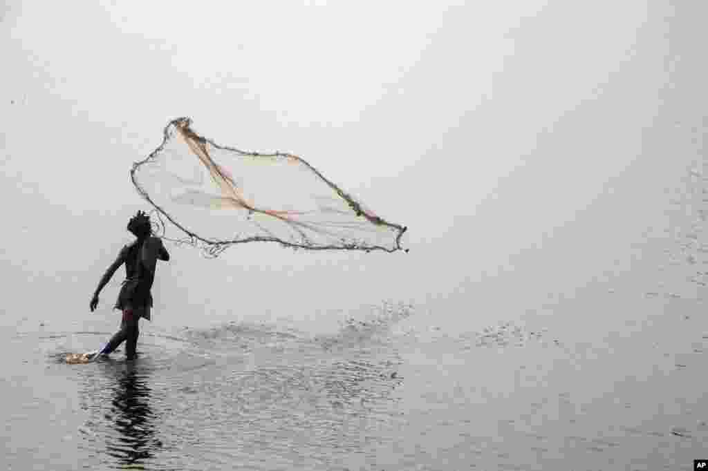 A fisherman casts his net in a lake on the outskirts of Muanda, western Democratic Republic of Congo, Dec. 23, 2023. 