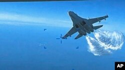 Foto yang diambil dari video yang dirilis pada Kamis, 16 Maret 2023, menunjukkan Su-27 Rusia mendekati bagian belakang drone MQ-9 dan mulai melepaskan bahan bakar saat melintas di atas Laut Hitam, kata Pentagon.(Departemen Pertahanan AS via AP)