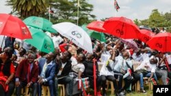 Members of the public react to military jets flying over during the national celebration marking Kenya's 60th anniversary of independence from Britain, known as Jamhuri Day, in Nairobi on December 12, 2023.