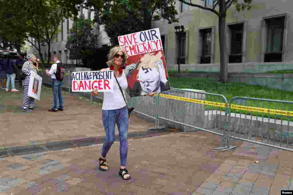 Una residente de Washington lleva un cartel en el que pide salvar la democracia, mientras muestra su oposición al expresidente Donald Trump.