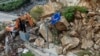 Machinery is used to remove rocks from a road in the aftermath of storms in Shijiaying, Fangshan district, on the outskirts of Beijing, Aug. 6, 2023. Multiple people have been killed in recent flooding in China's capital. (Xinhua via AP)