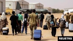 যুদ্ধ বিরতি শুরু হলে নিরাপদ গন্তব্যে ছুটে যাচ্ছে লোকজন। সুদানের ওয়াদি সিদনা বিমান ঘাঁটি থেকে তোলা ছবি। ২৭ এপ্রিল, ২০২৩। 
