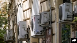 Air conditioning external units are seen on the wall of a building in Rome, July 25, 2023. 
