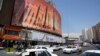 Vehicles in Tehran, Iran, drive past an anti-Israeli banner showing missiles being launched, April 19, 2024. The threat of a wider war between Israel and Iran may give U.S. President Joe Biden more breathing room to provide military assistance to Israel without restrictions.